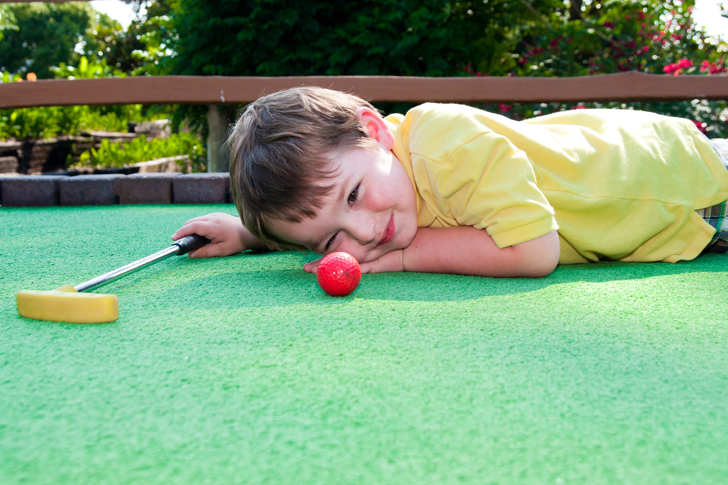 Kid laying on the mini golf course